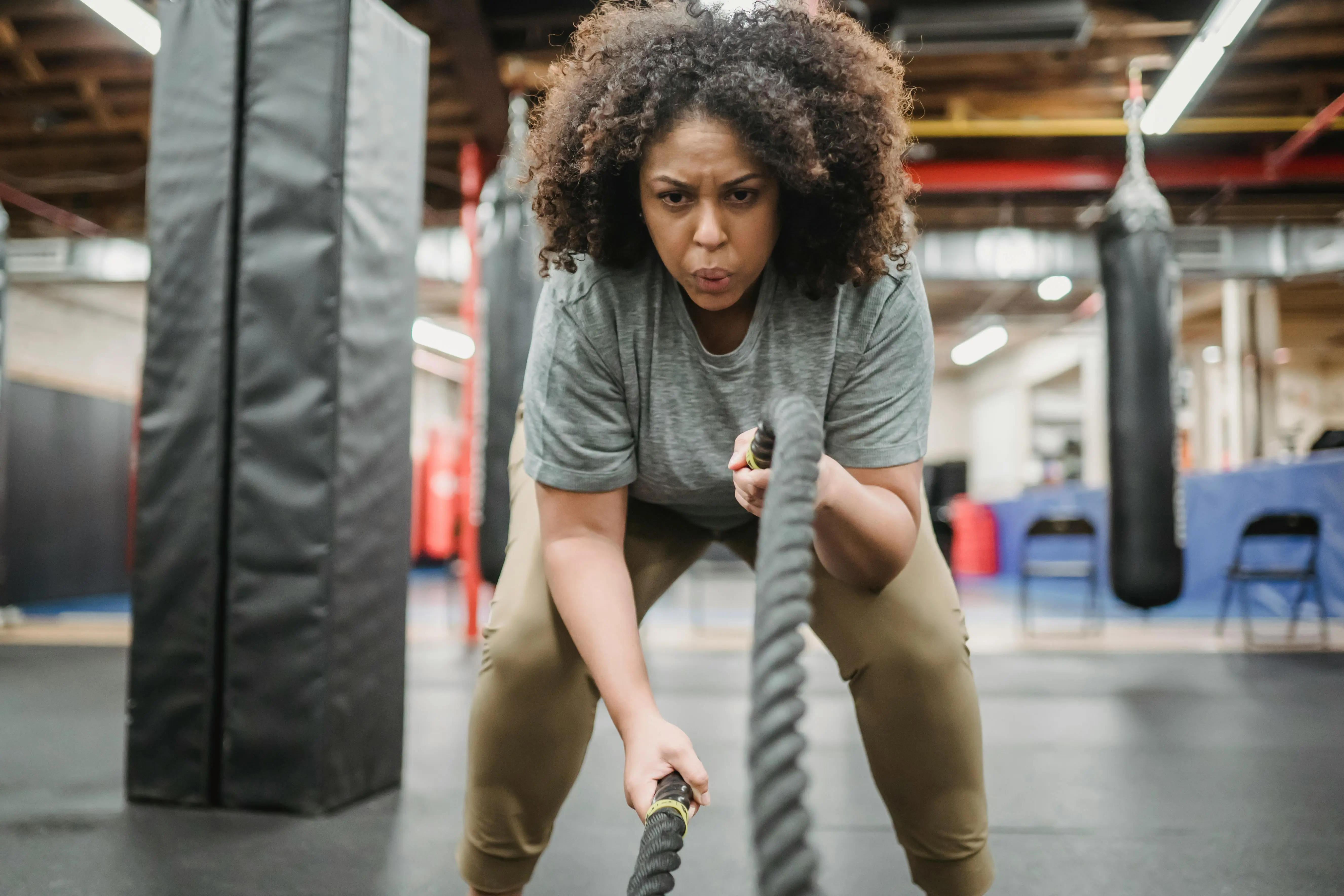 A woman using battle ropes in a gym