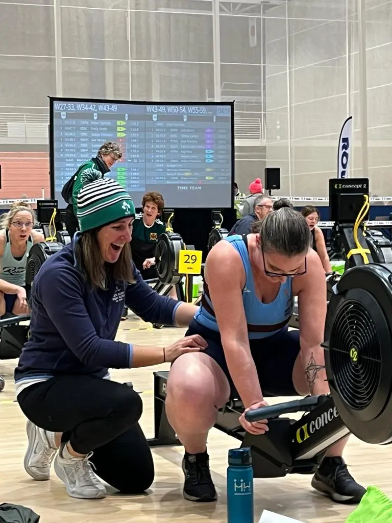 A rower and her coach at an indoor rowing competititon